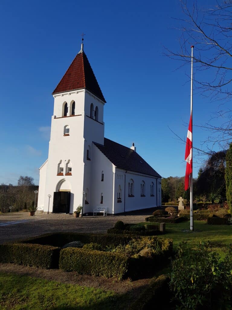 Kirke med flaget på halv til en bisættelse
