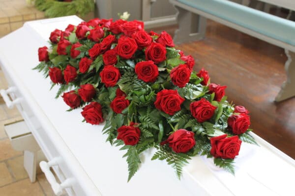 Klassisk kistepynt i en oasis bestående af røde roser