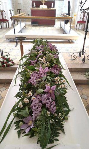 hvid kiste med lilla blomster bisat i Haarby kirke