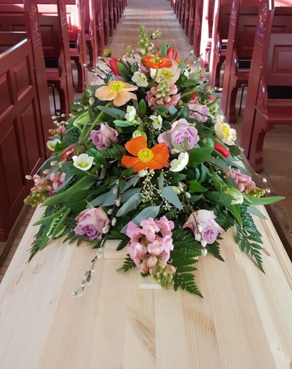 Bæredygtig begravelseskiste af nordisk fyr med smukke blomster