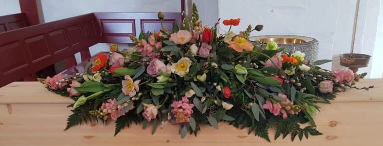 kiste med smukke blomster i forskellige varme farver